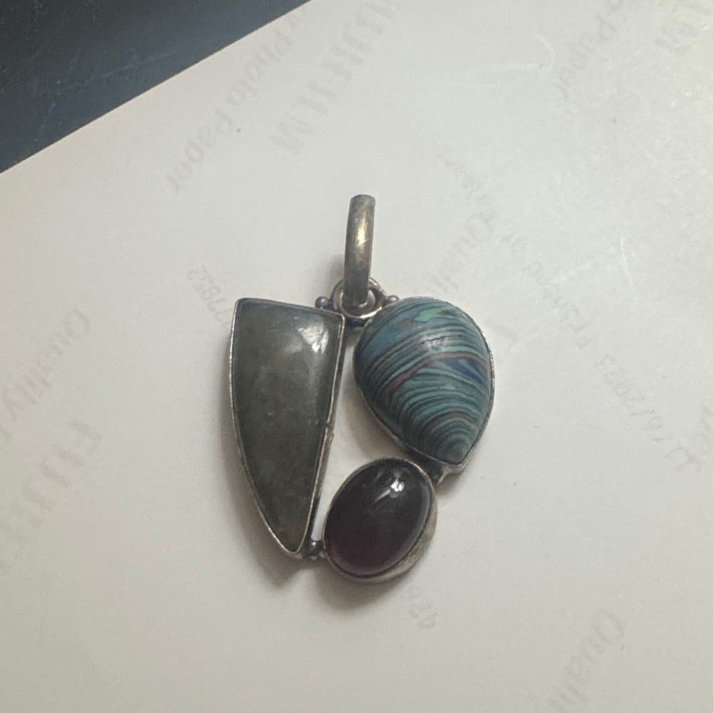 Sterling silver pendant with rainbow calcite, garnet, and textured grey stone.
